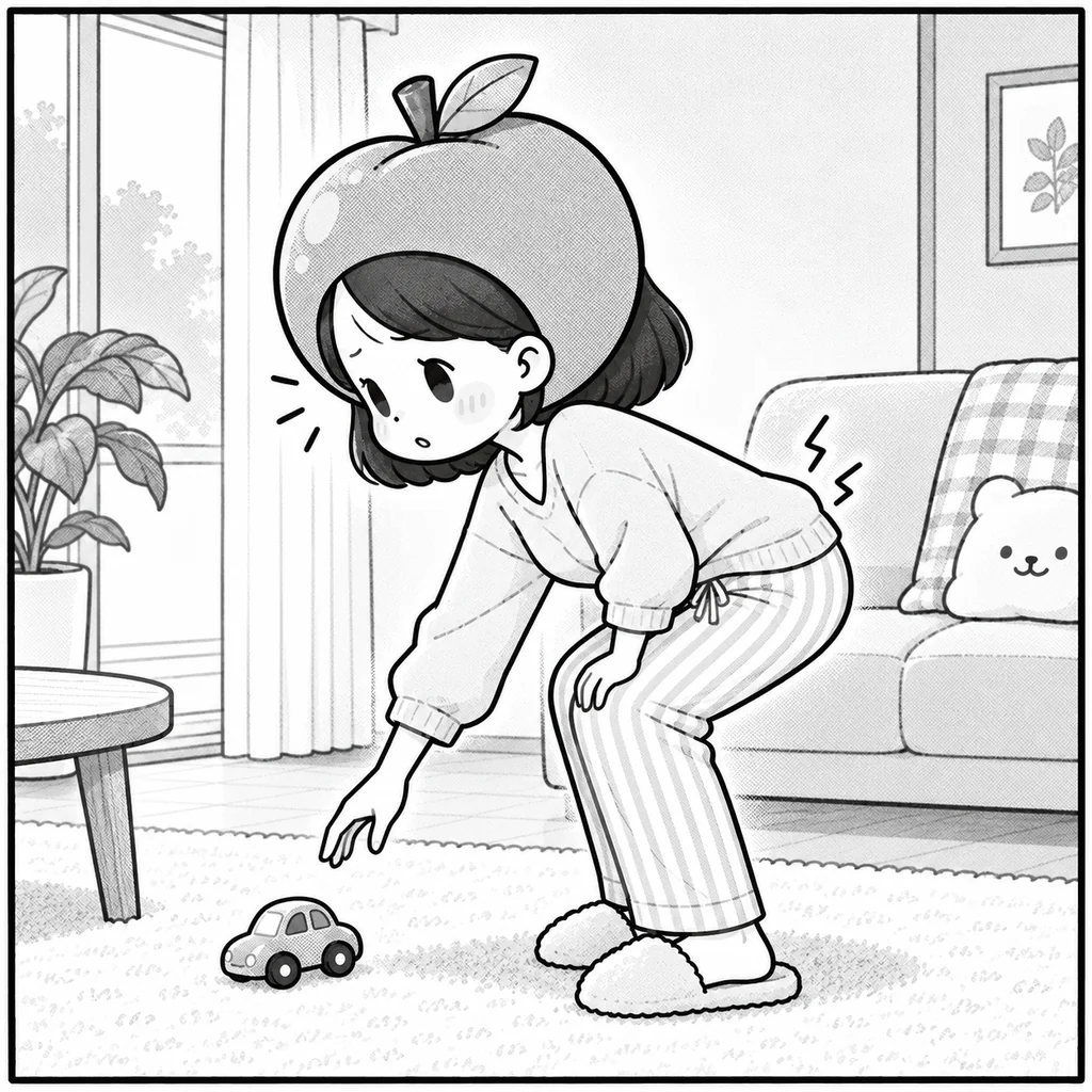 床のおもちゃを拾おうとして、しゃがみ切れずに中腰で止まっているりんごナース。腰に痛みの印